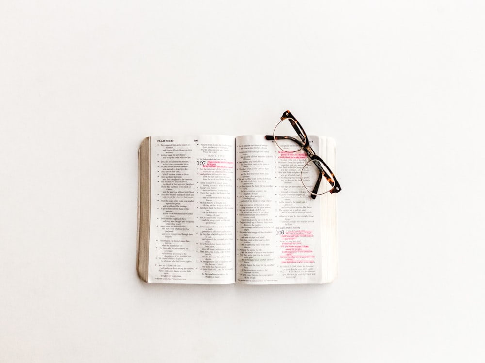 white book page and eyeglasses