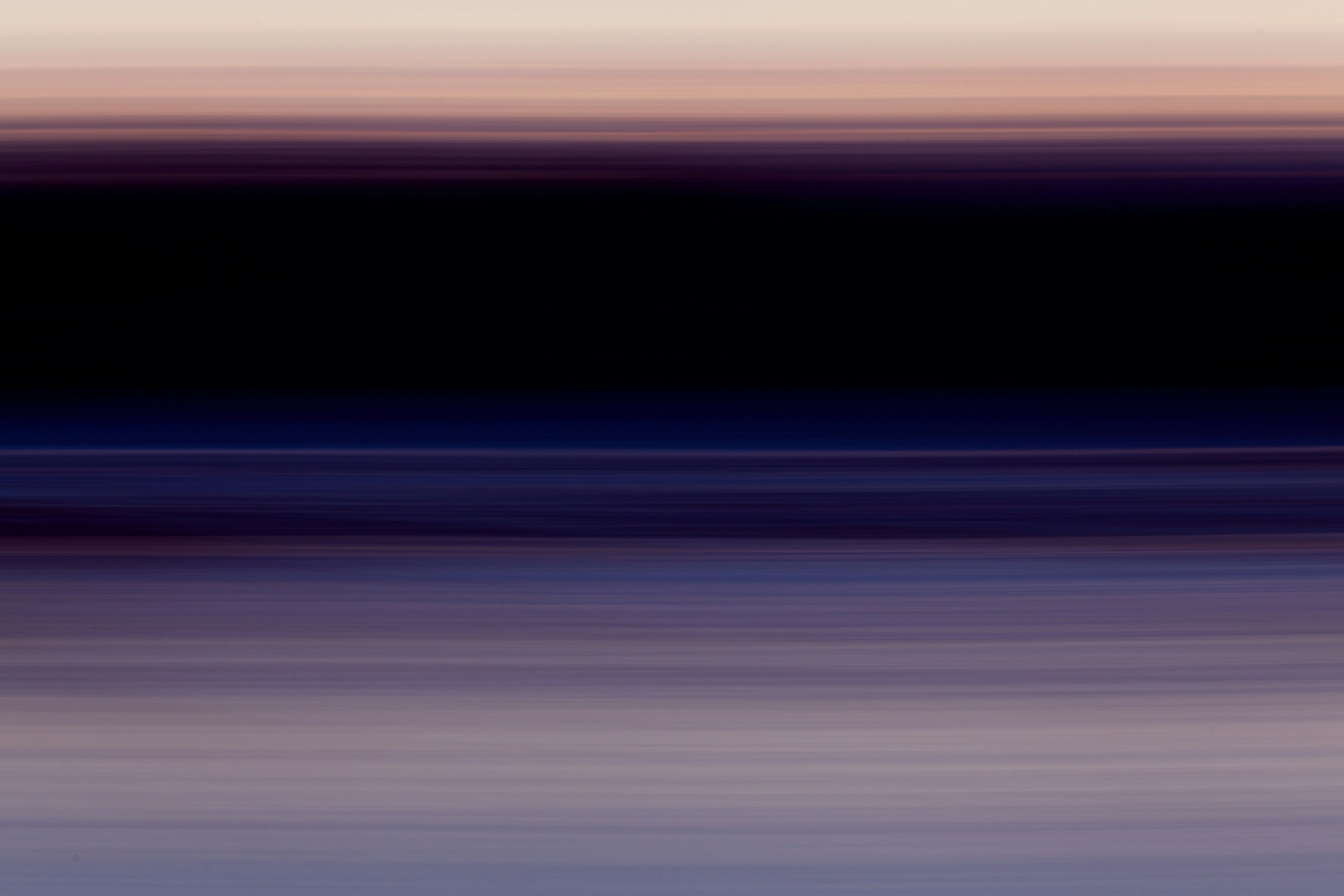 Blurred landscape of beach and dark rainforest at sunset