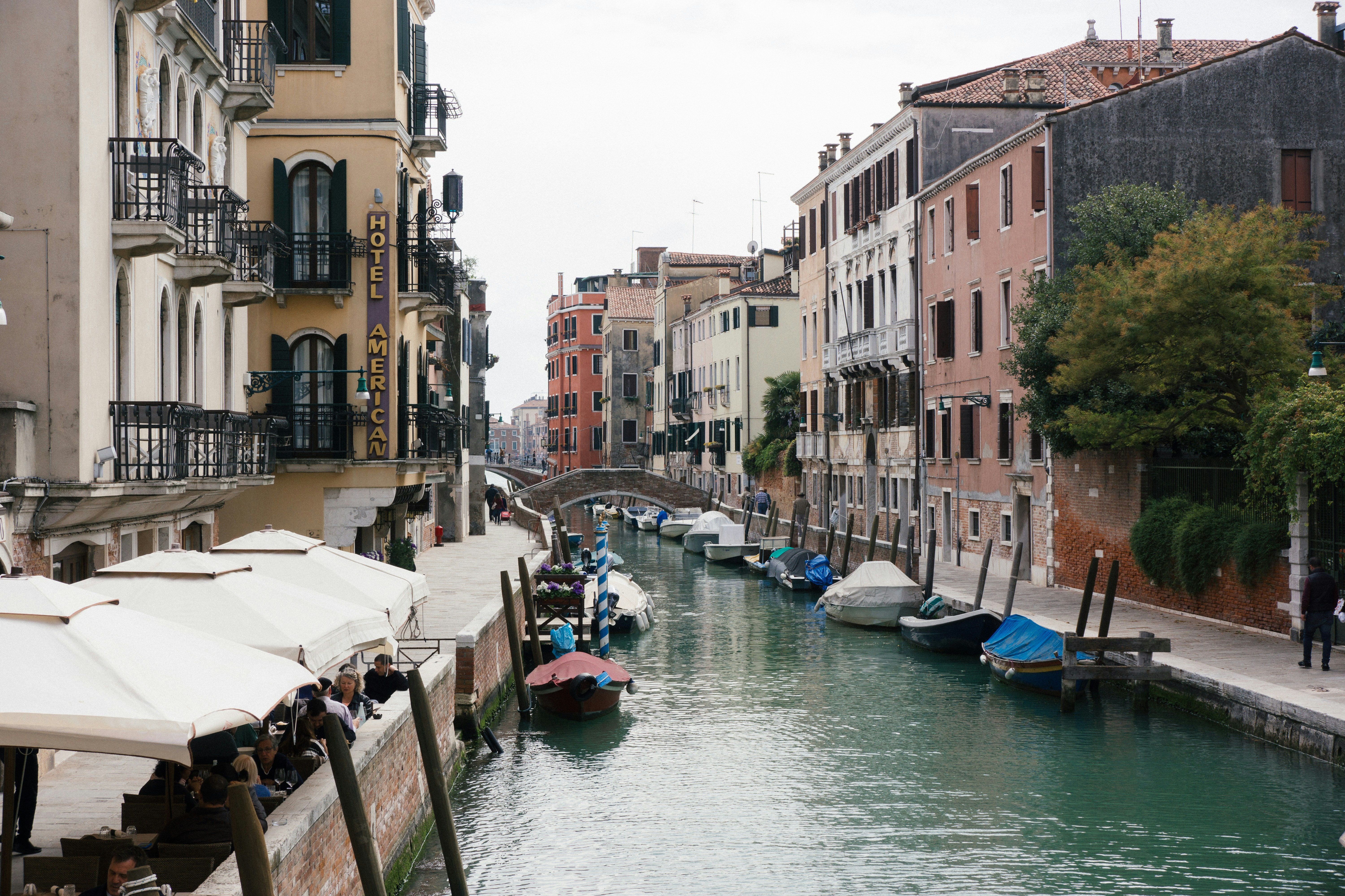 boats docked beside the road near buildings