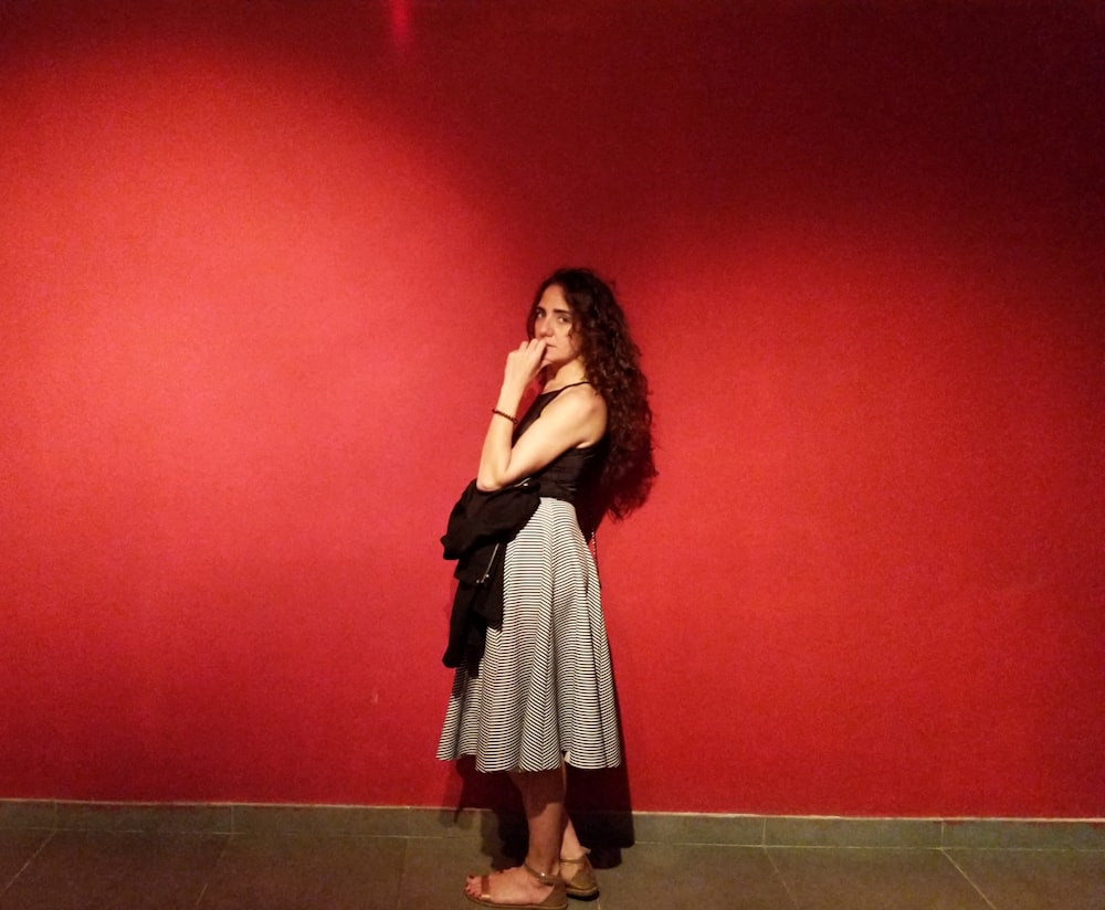 woman wearing black tank top besides red wall
