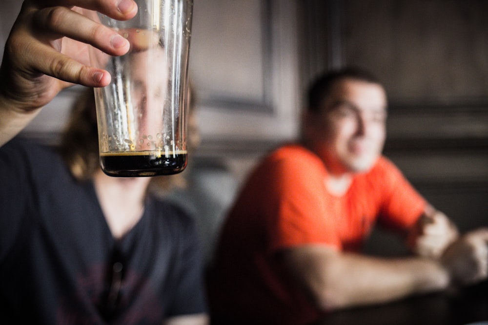 unknown person holding clear drinking glass