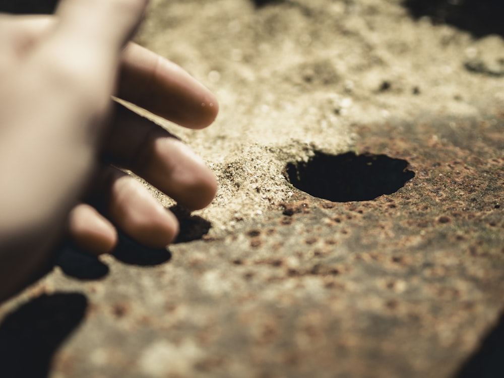 person's hand near hole