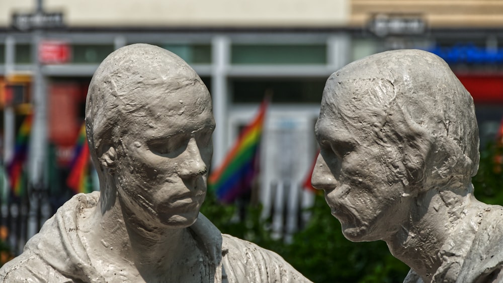 two human sculptures near building