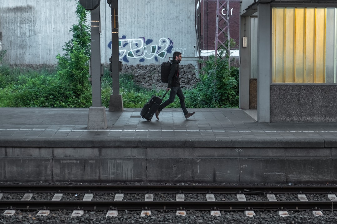 man walking beside train trail