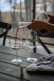 person pouring wine from decanter on wineglass