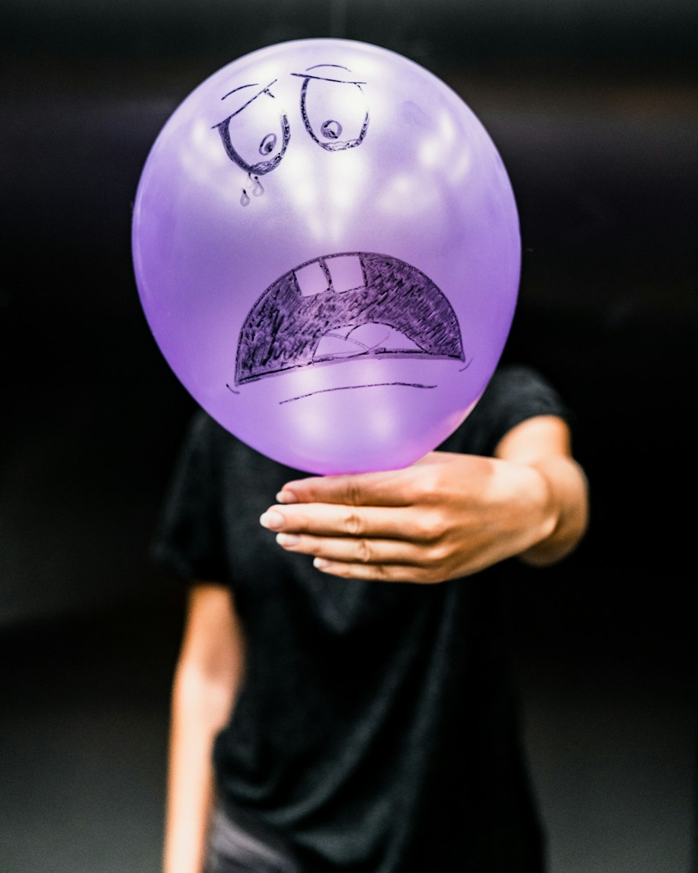 man in black t-shirt and purple balloon