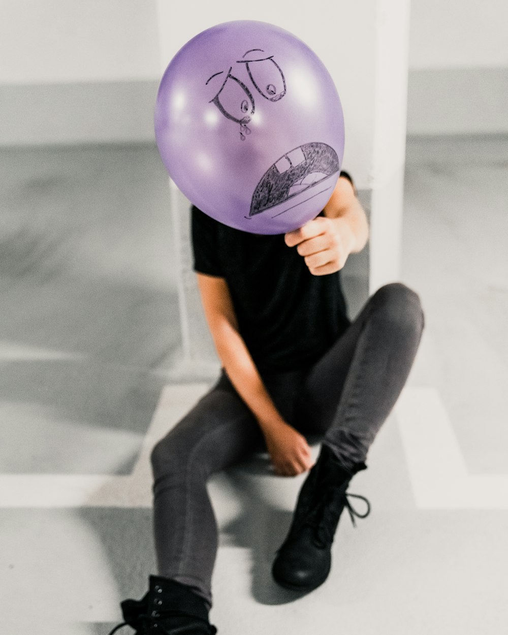 sitting man holding sad balloon