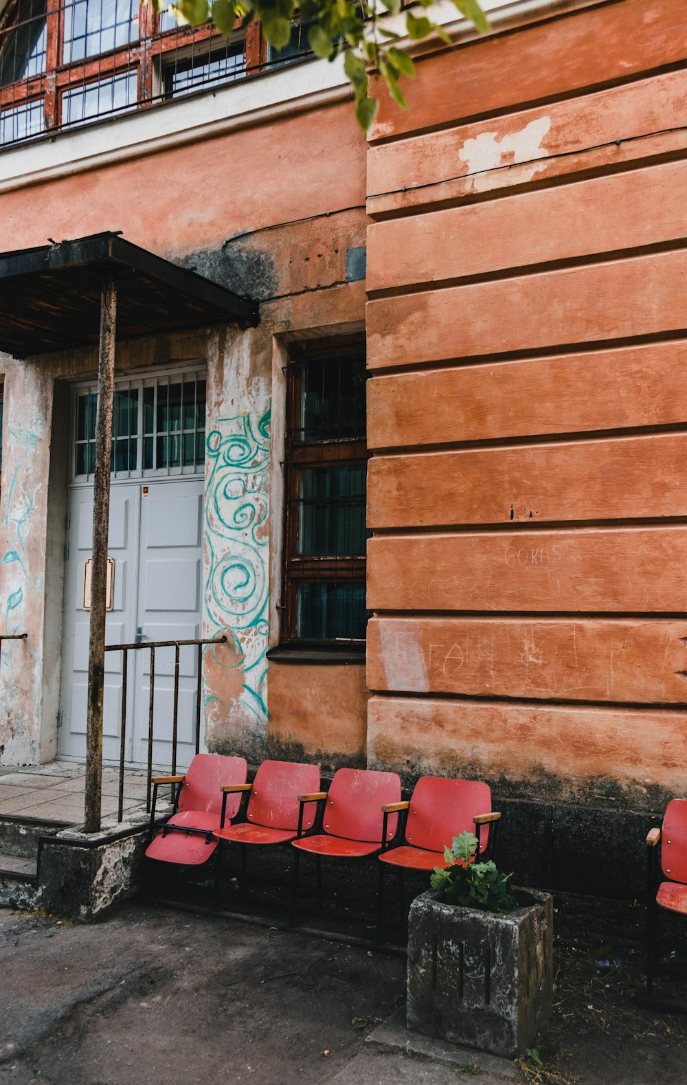 red plastic chairs near gray wooden door