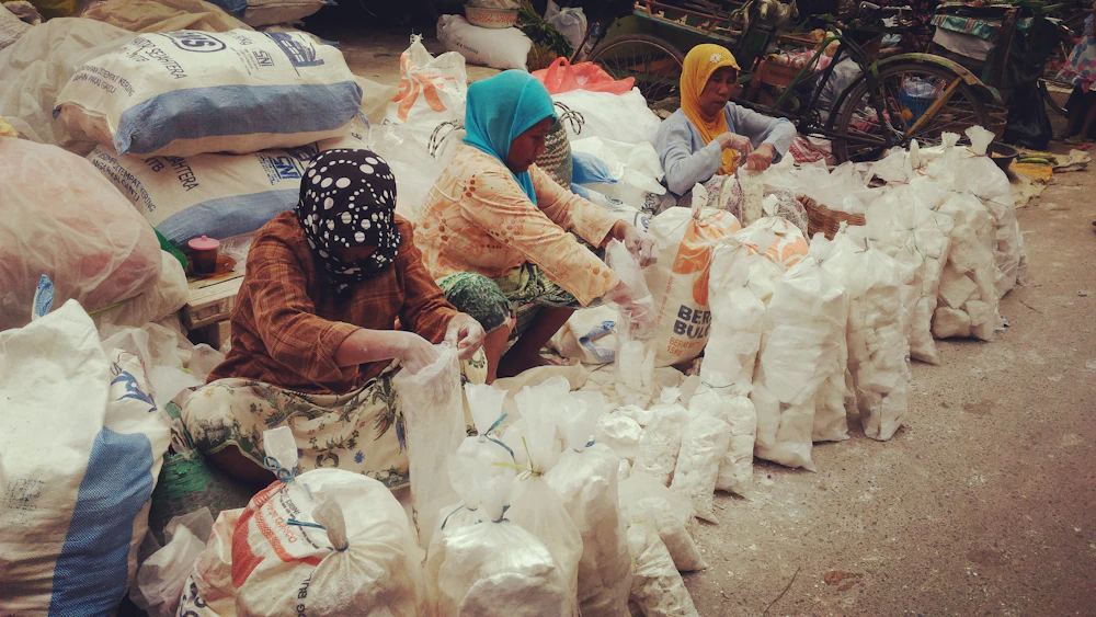 Volunteers standing beside sacks of food aid