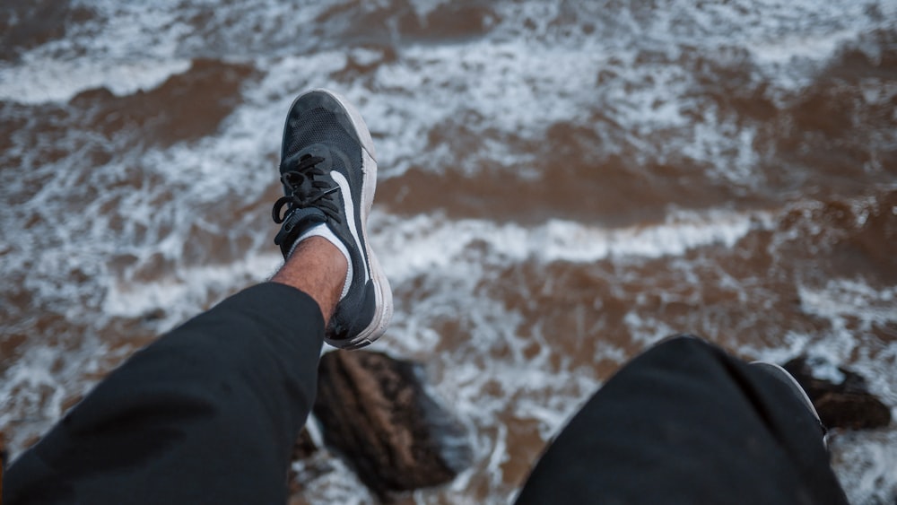 person in black pants with black-and-white Nike low-top sneakers