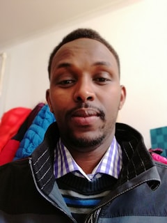 Street style shot of a person in layered anxiety clothing pieces against a minimalist wall