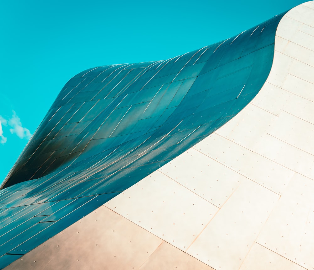 a curved metal structure against a blue sky