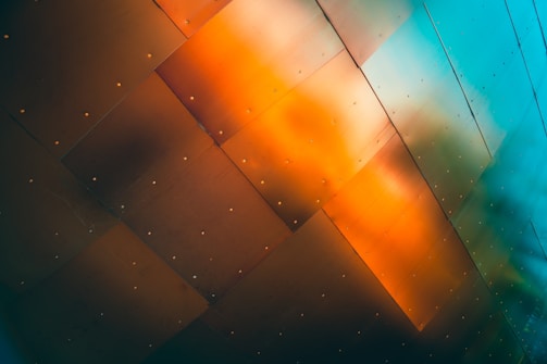 Industrial-grade steel panel with metallic gradient and neon orange accents under harsh lighting.