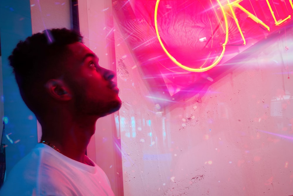 person looking at a pink sign close-up photography