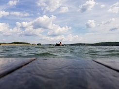 brown wooden dock and person riding on boat during daytime