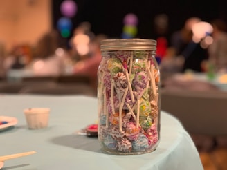 A bright, elegant candy buffet table filled with colorful sweets and decorative jars at a lively party.