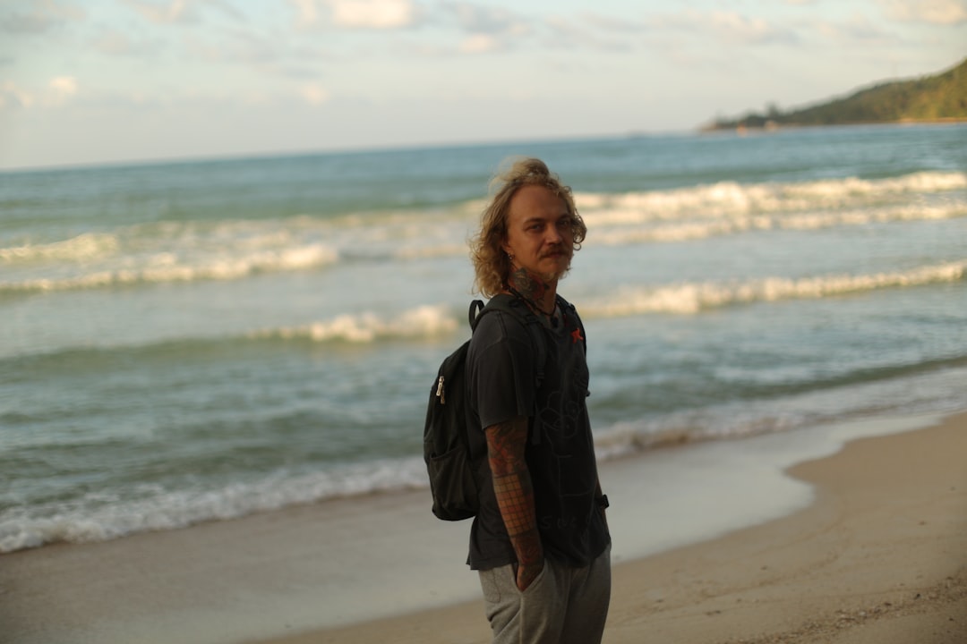 man standing on shore during daytime