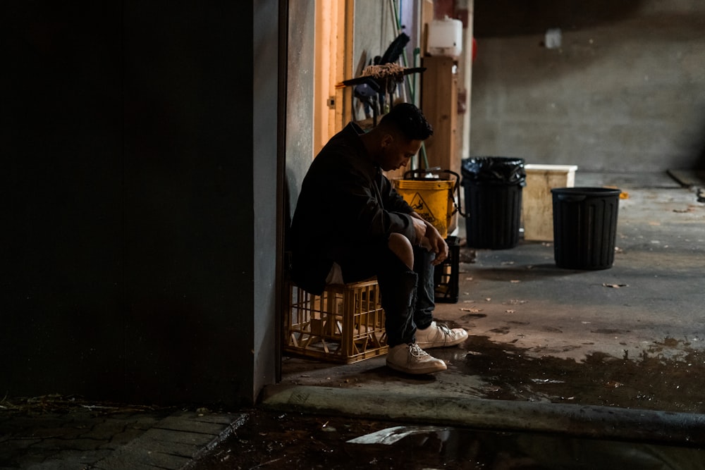 man siting on chair beside wall