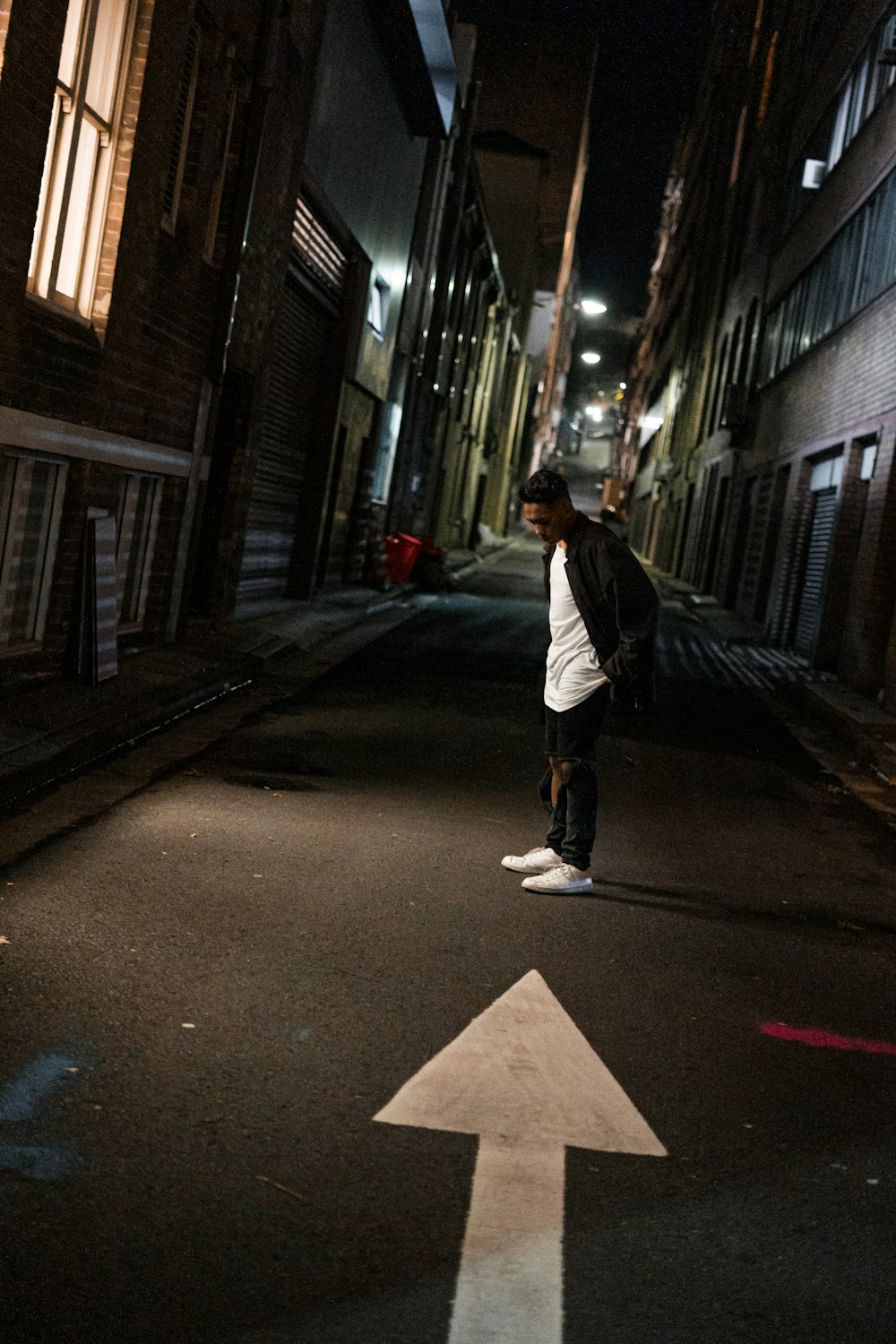 man standing on road near building