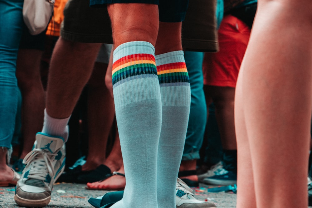 persona que usa calcetines hasta la rodilla verde azulado y multicolores