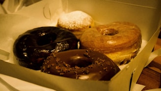 An open box showing a variety of donuts with chocolate, vanilla, and fruit toppings.