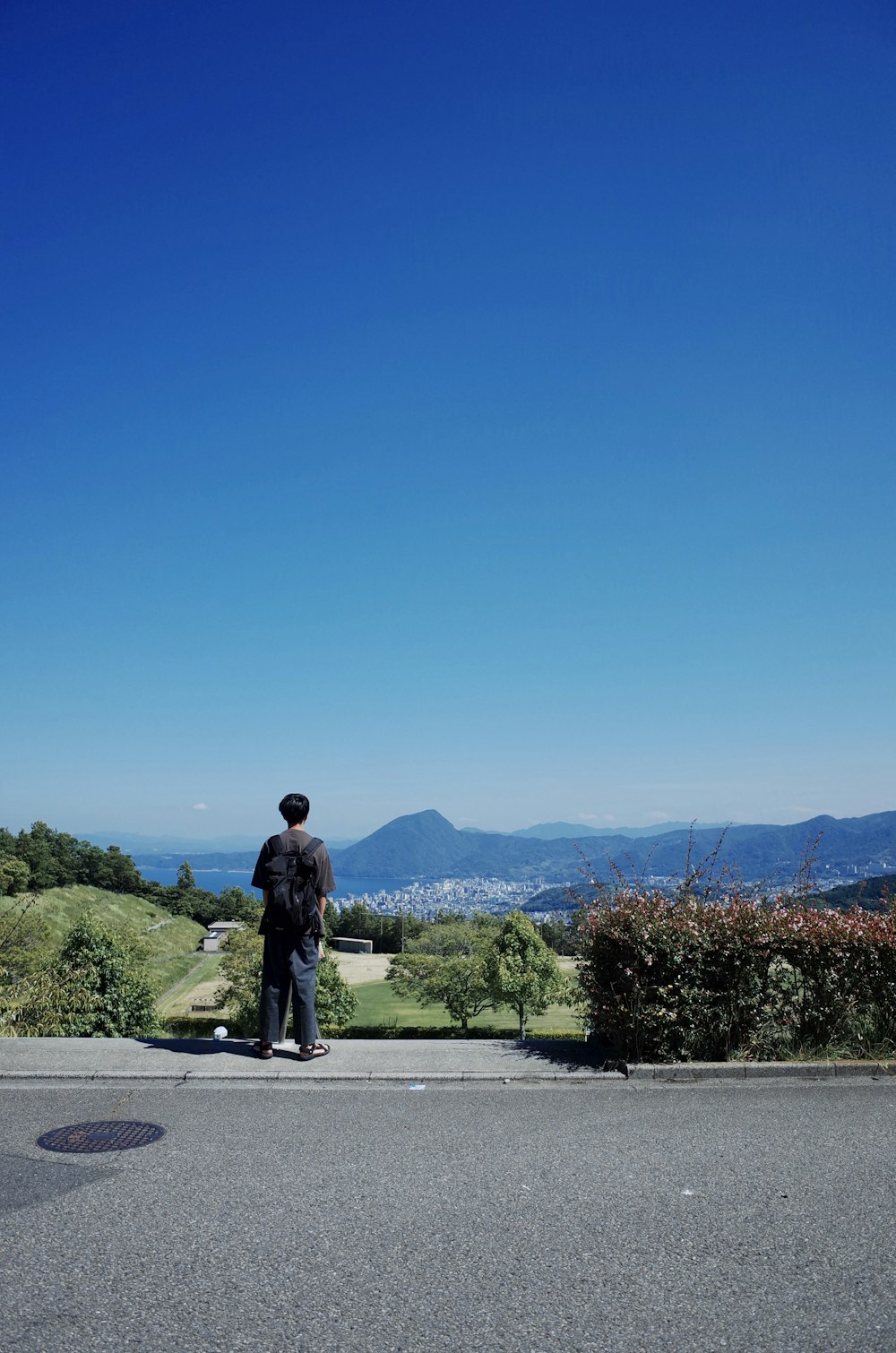 person in black T-shirt standing near plants