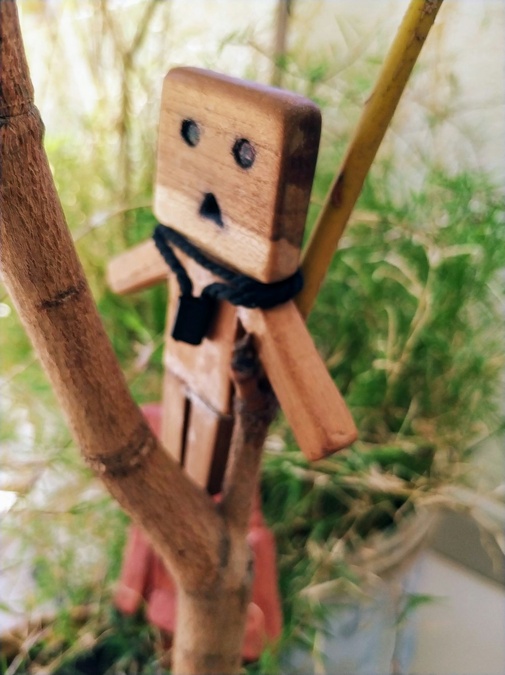 brown wooden character toy on wooden twig