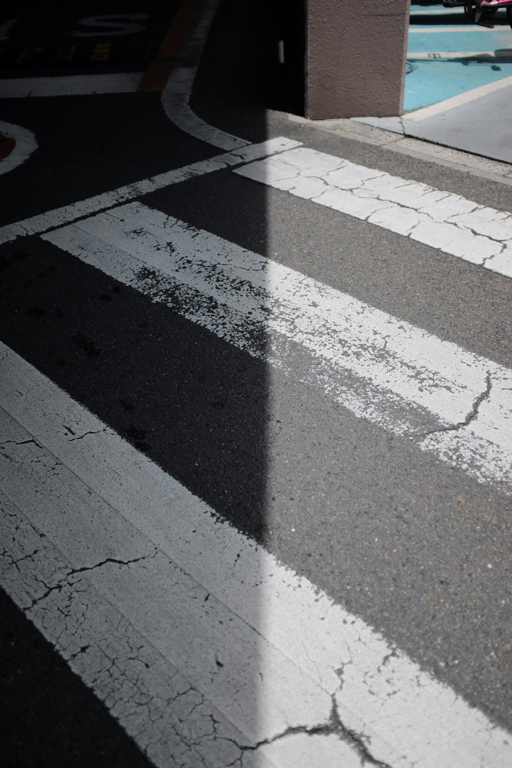 a street with a crosswalk and a building in the background