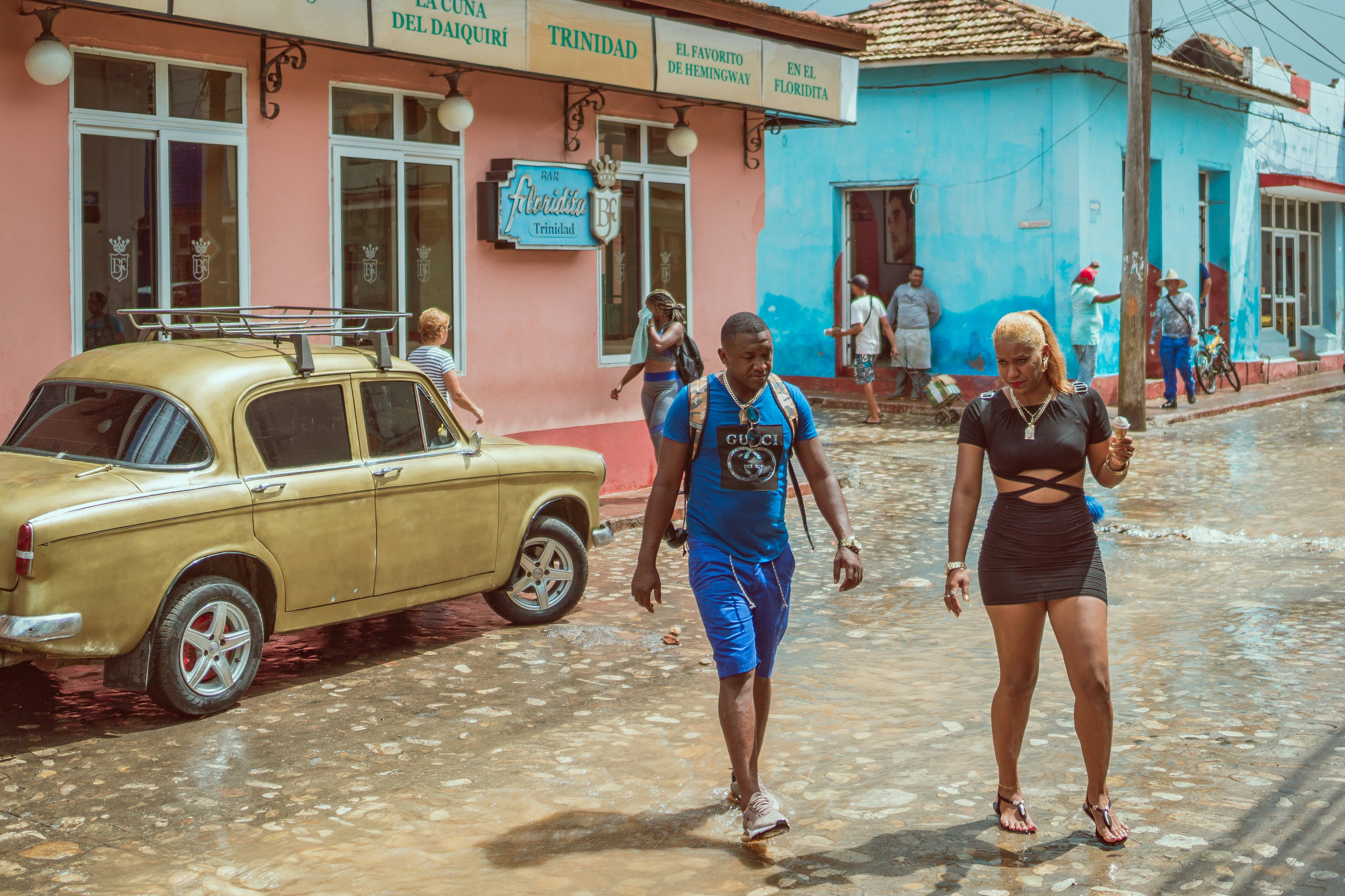 man and woman crossing street during daytime