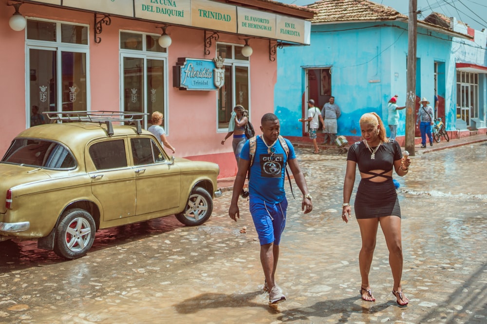 man and woman crossing street during daytime