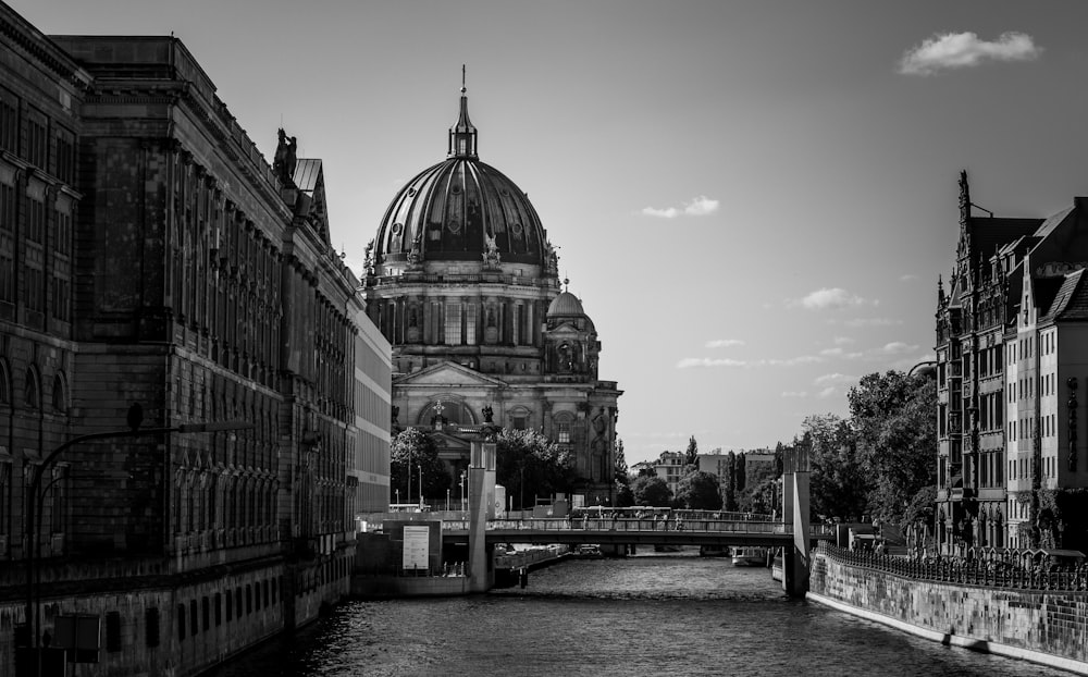 grayscale photography of buildings near body of water