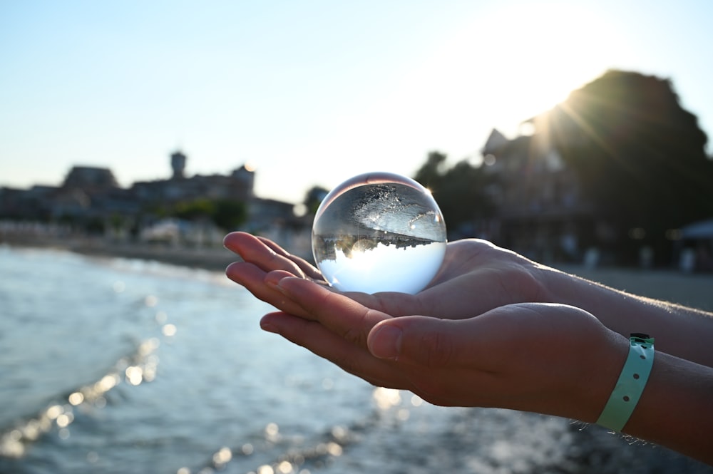 person holding clear glass ball