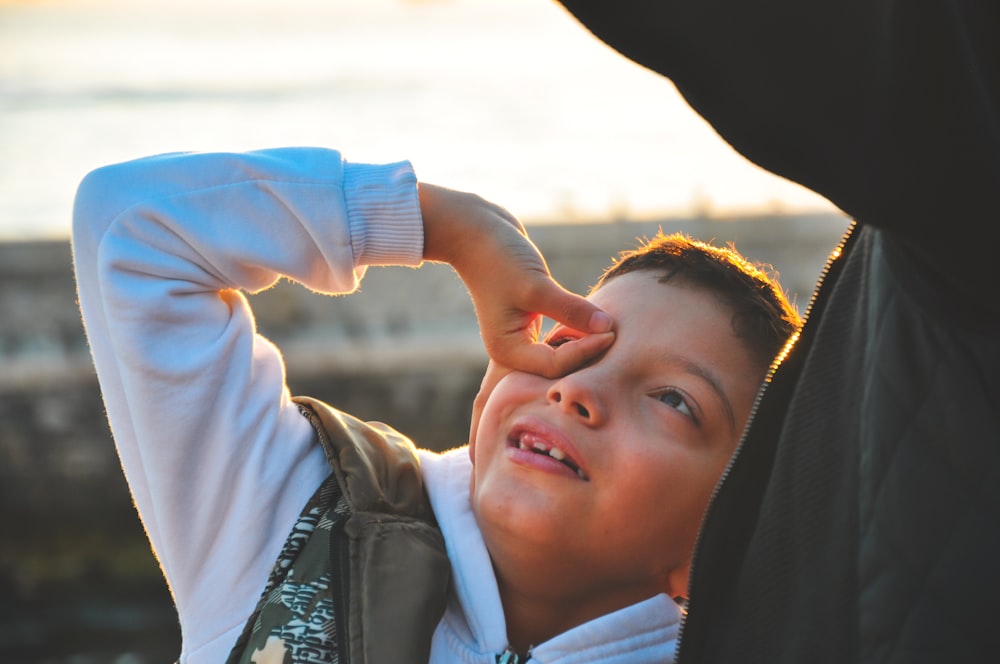 boy twisting his hand and puts on top of his eye