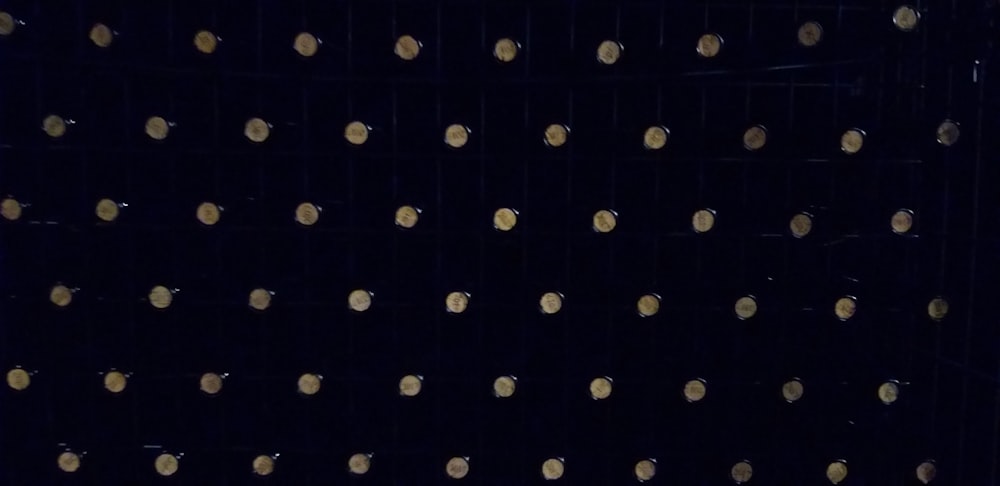 a close up of a black wall with gold dots