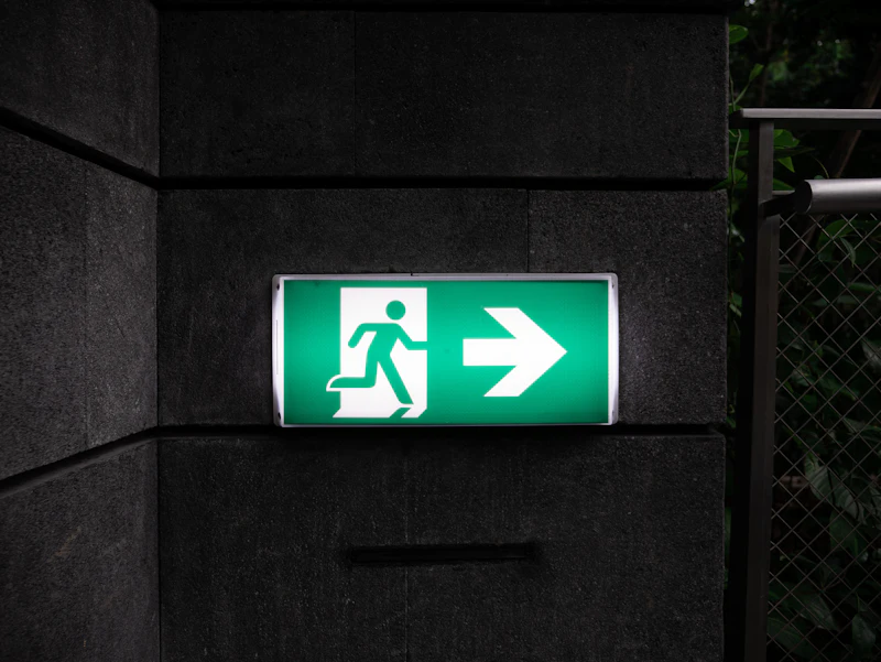 Illuminated fire exit sign in a building corridor