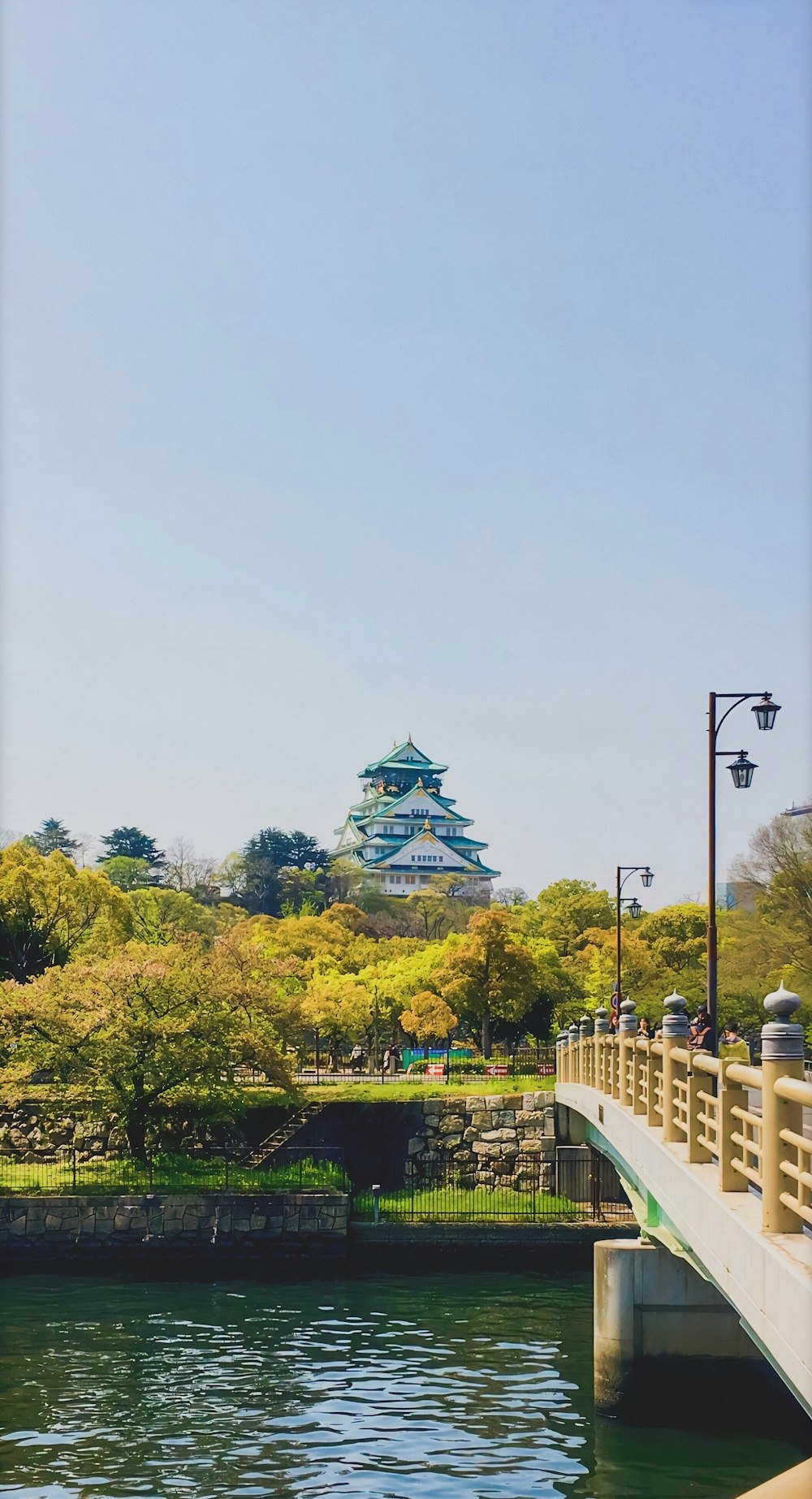 a bridge over a body of water with a building in the background