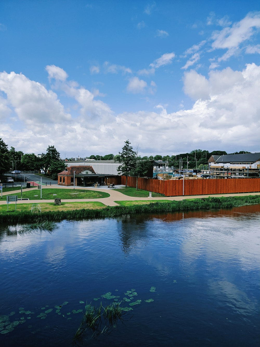 houses with red fence beside body of water