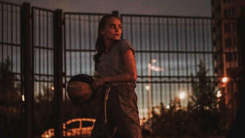 woman holding a black and white basketball ball