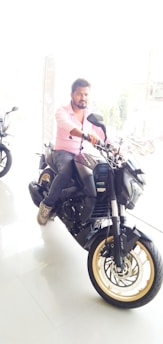 A friendly sales advisor discussing options with a customer beside a motorcycle.