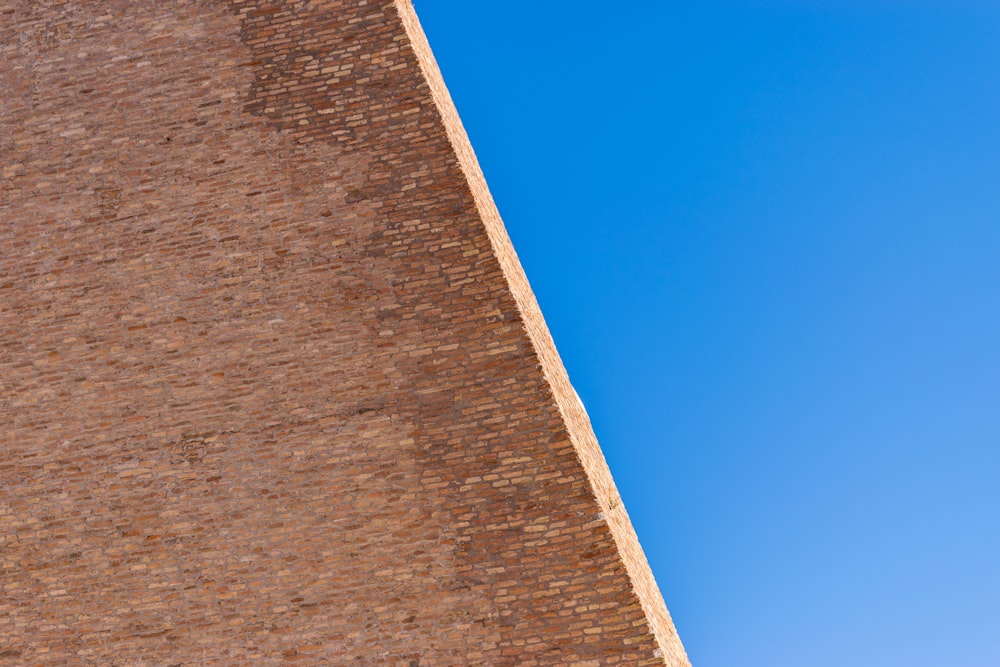 a stop sign on a brick wall with a blue sky in the background