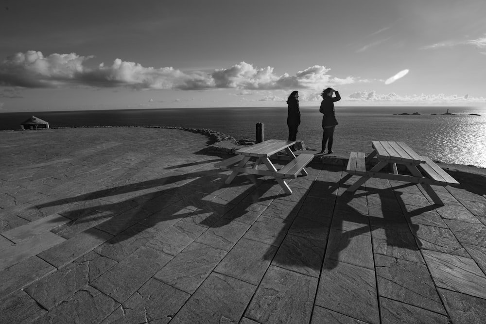 two women standing near ocean