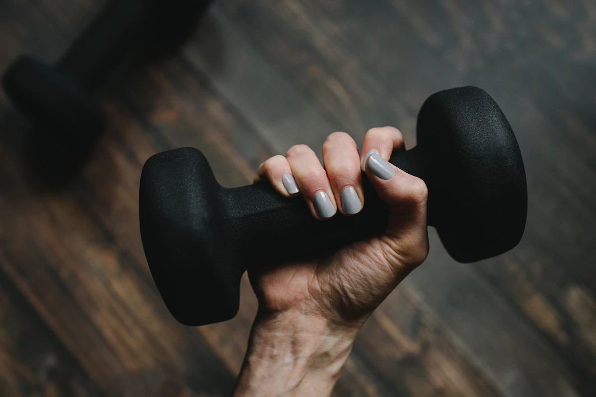 A hand gripping a black dumbbell