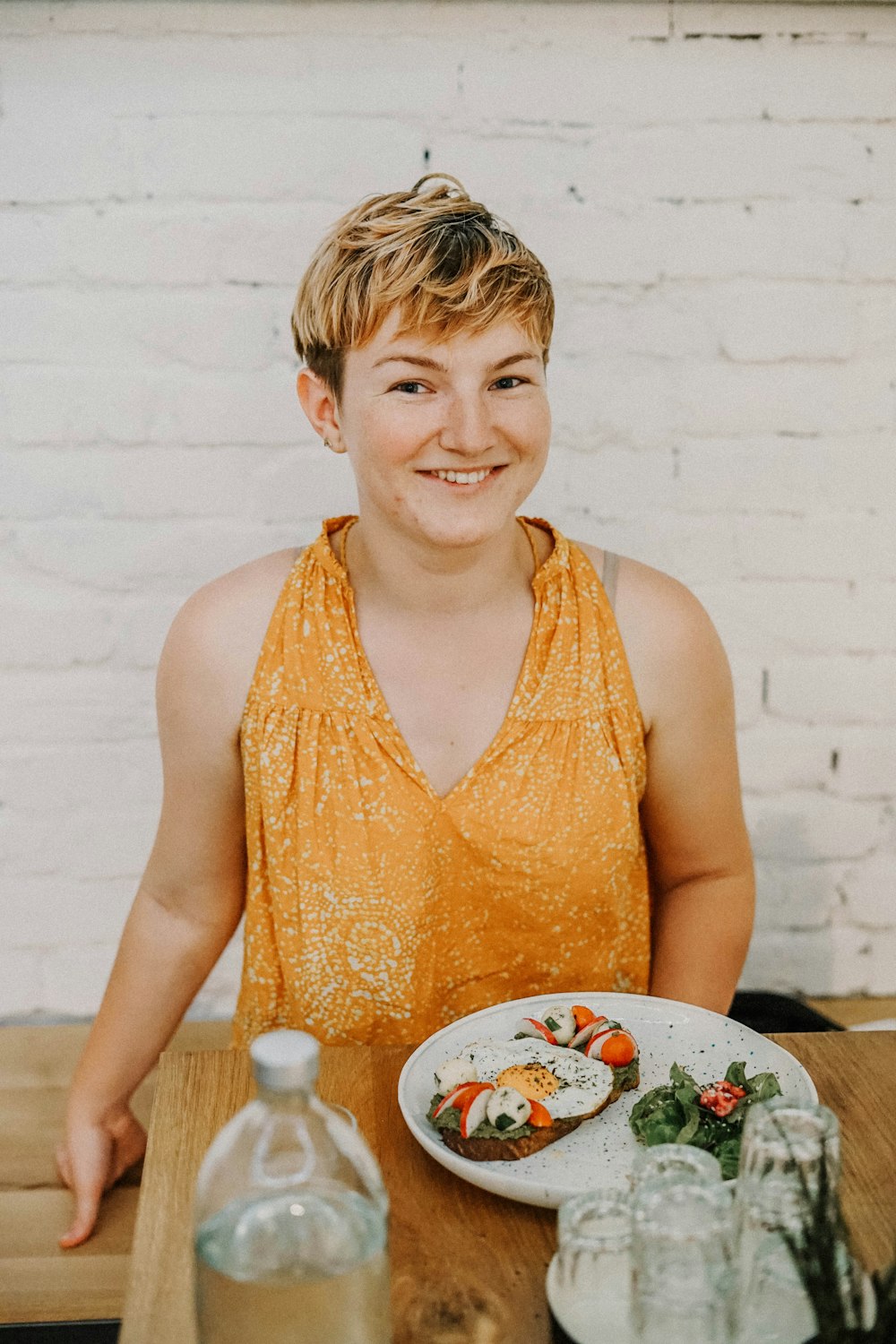 women sitting beside a full plate close-up photography