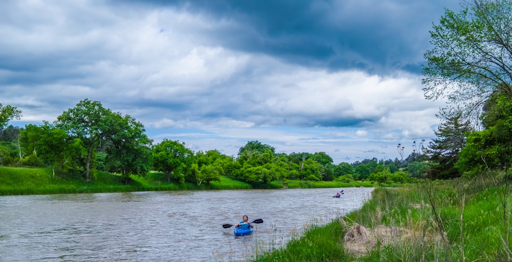 man kayaking on a river during daytime