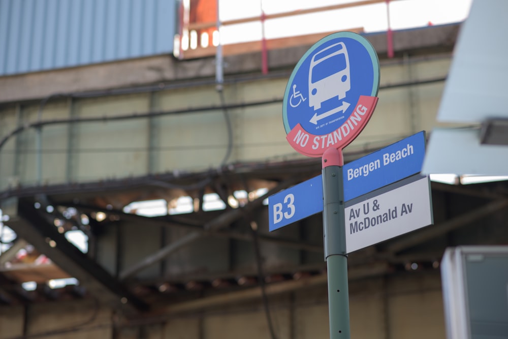 blue and red no standing on bus road signage