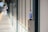 A plastic bottle with a blue label and cap is placed on top of an emergency call box at a train or subway platform. The platform is mostly empty, with blurred background showing part of the tracks and another person in the distance.