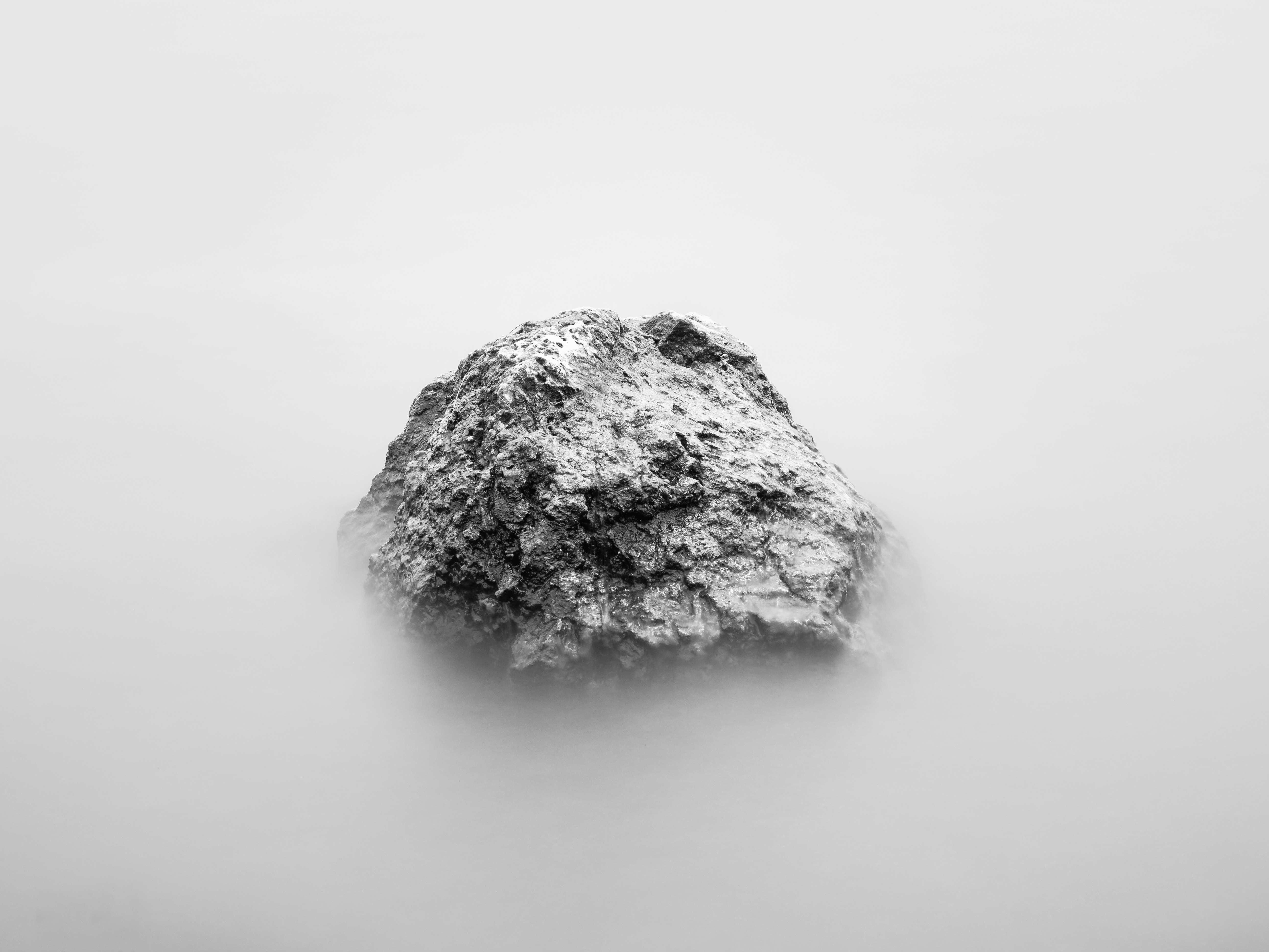 gray rock formation surrounded by clouds