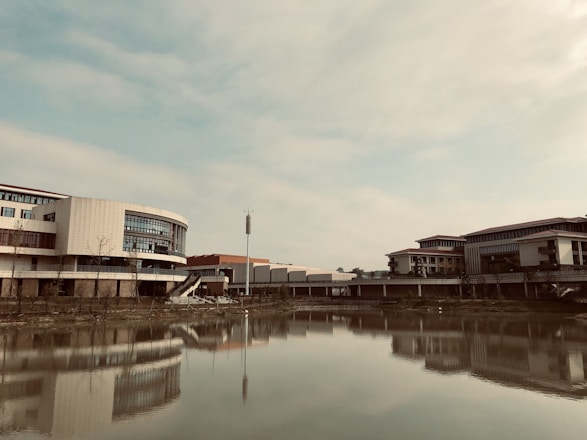 A serene landscape blending modern eco-friendly buildings with lush greenery under a clear blue sky.