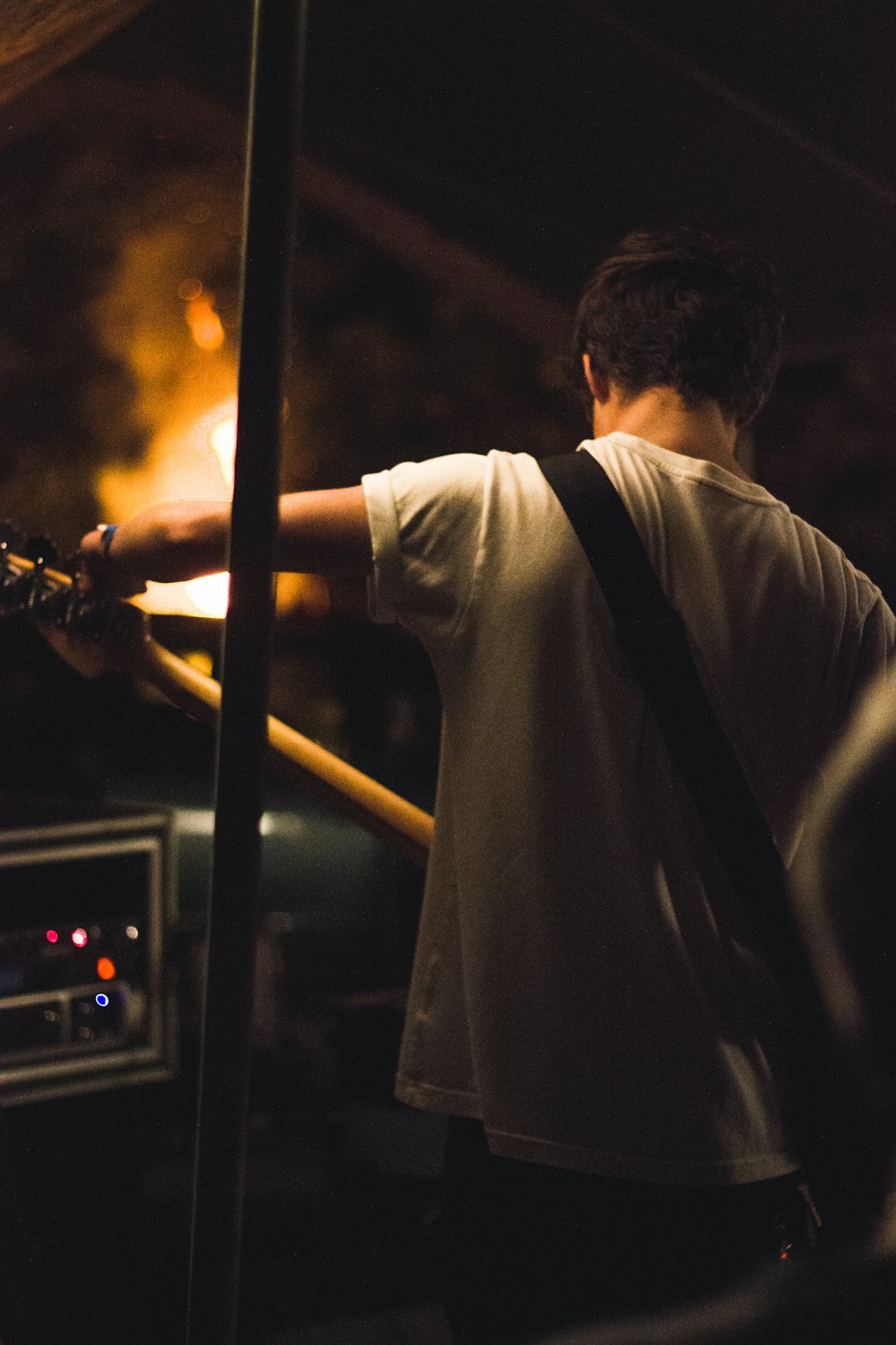 man wearing white shirt playing electric guitar