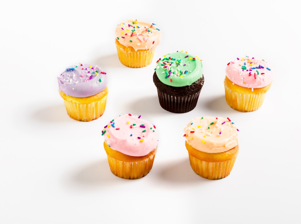 assorted cupcakes on white surface